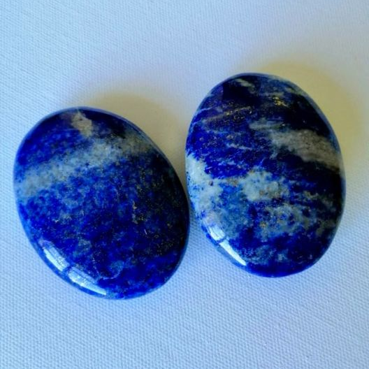 Two lapis palmstones on light gray background