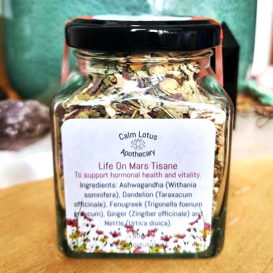 Jar of Calm Lotus Apothecary Life On Mars Tisane on a wooden surface with a blurred background