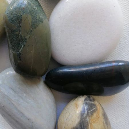 Collection of variously colored New Zealand stones on a textured surface