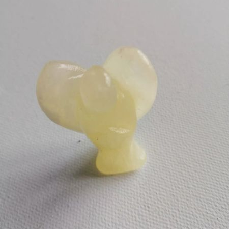 Small yellow angel figurine on a gray background