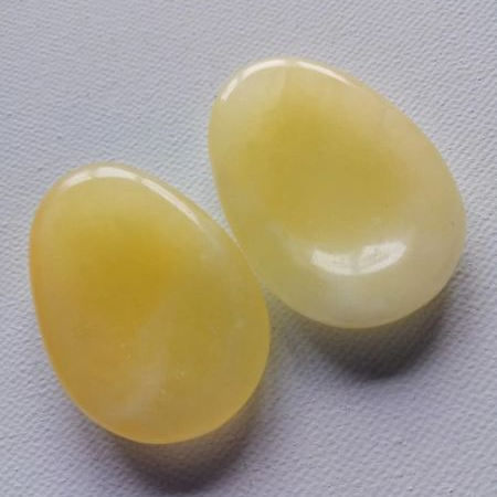 Two yellow thumb stones on a gray background