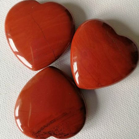 Three red heart-shaped objects on a white background