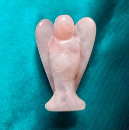Pink angel-shaped crystal on a teal background