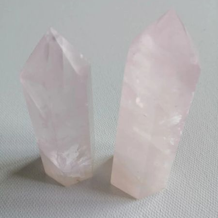 Two pink crystal points on a light gray background