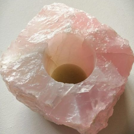 Pink crystal with a central hole for tealight candles on a white background