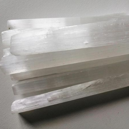 Selenite crystal rods on a gray background