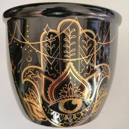 Black smudge stick holder with gold Hamsa hand design on a white background
