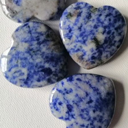 Heart-shaped stones with blue and white speckled pattern on a white background