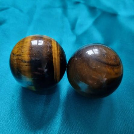 Two tiger eye orbs on a blue fabric background