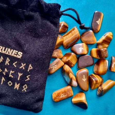 Set of runic stones with a black drawstring bag on a blue background